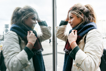 A young girl looks at her reflection