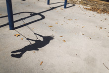 Shadow Of Boy Swinging At Park