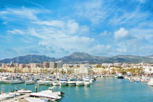Benalmadena Puerto Marina Sport Port, A View To Piers With White Modern Luxury Sport Yachts, Mediterranean Sea And Mountains And Cloudy Sky At The Background. Spain Winter Relax Vacation Concept.
