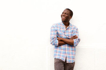 smiling young man with arms crossed and looking away on white background