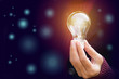 Innovation or creative concept of hand hold a light bulb on bokeh background.