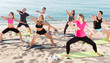 © JackF - People practicing yoga on beach