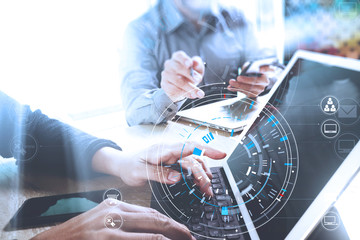 Poster - Businessmen working together on a document and using smart phone and digital tablet and laptop computer in modern office with VR icon diagram