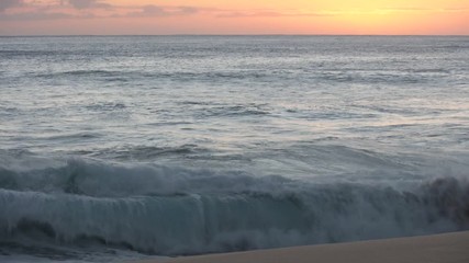 Wall Mural - shorebreak ocean waves near rocky coast and cliffs, rough sea water at sunset time