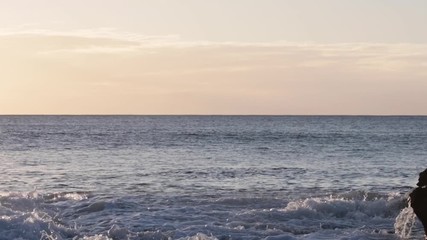 Wall Mural - shorebreak ocean waves near rocky coast and cliffs, rough sea water at sunset time