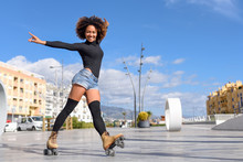 Black Woman On Roller Skates Riding Outdoors On Urban Street