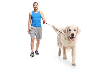 Young Man In Sportswear Walking A Dog