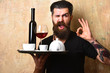 Man with beard holds various drinks on beige wall background