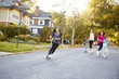© Monkey Business - Three pre-teen girls playing in street on scooters and bike