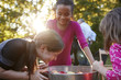 © Monkey Business - Young girls laugh while apple bobbing at a backyard party