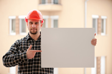 Construction worker holding blank white board