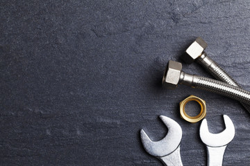 Plumbing concept. tools and pipes on a dark slate bakground