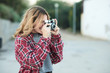 © Guille Faingold/Stocksy - Smiling girl taking shot with film camera.