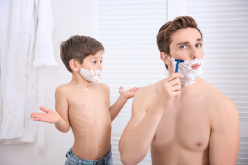 Wall Mural - Father and his little son shaving in bathroom