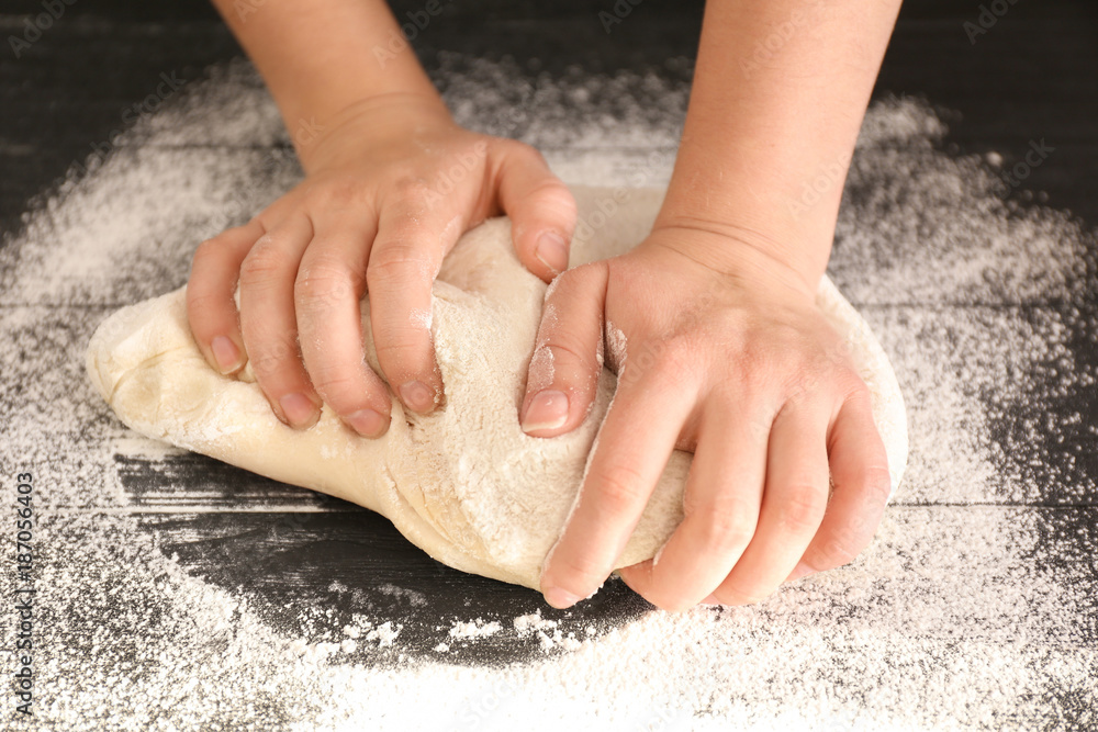 Woman kneading puff pastry on table
