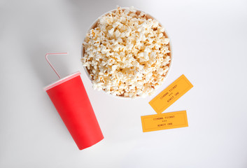 Wall Mural - Tasty popcorn, cup with drink and movie tickets on white background, top view