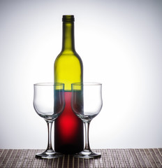 Bottle of red wine and wine glasses / open bottle of red wine and two empty glasses standing on the table