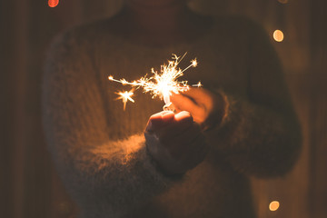 Burning sparkler in a woman hand, new year, christmas holiday concept.