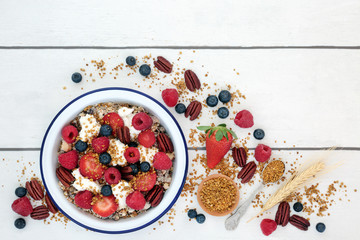 Wall Mural - Healthy fresh breakfast concept with granola, pollen grain, yoghurt, berry fruit, nuts with foods high in protein, omega 3, anthocyanins, antioxidants, minerals and vitamins. Top view.