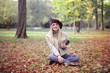 © olly - Smiling girl sitting on autumn leaves