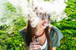 © mnelen.com - Happy fashion smiling Woman in sunglasses smoking vape on street,smoke