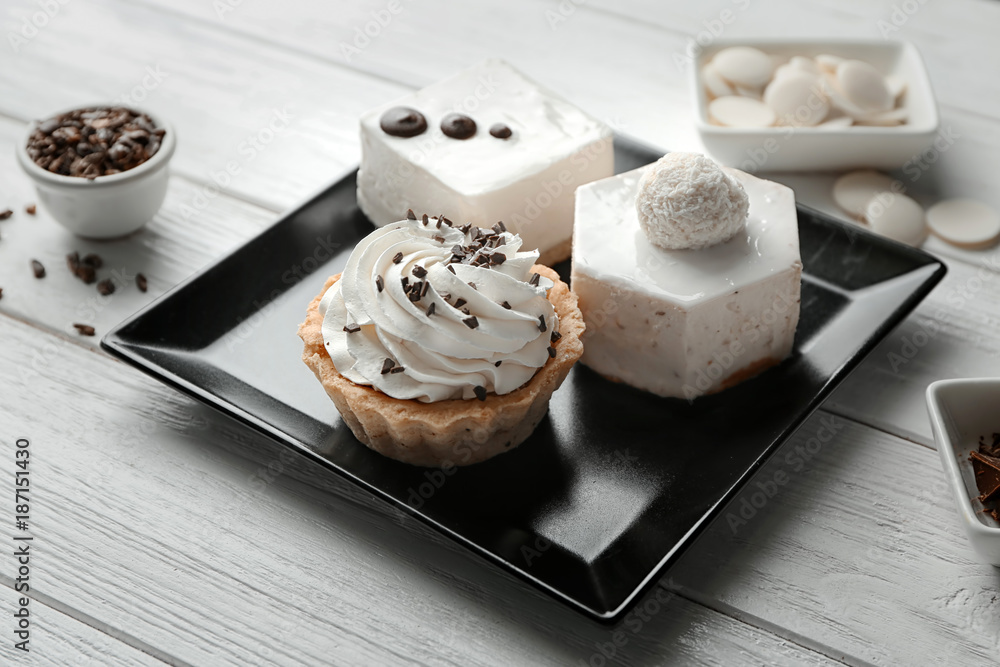 Plate with tasty pastries on wooden background