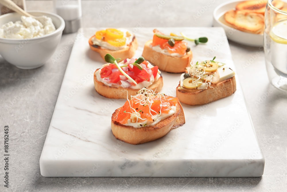 Marble board with tasty fresh bruschettas on table