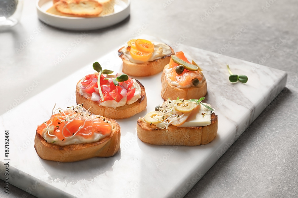 Marble board with tasty fresh bruschettas on table