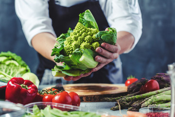 Wall Mural - Chefkoch in der Küche mit Frischem Gemüse(Romanesco Kohl)