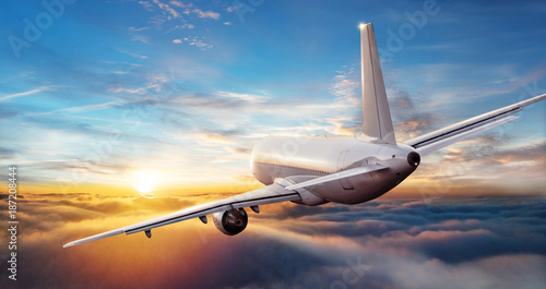 Fotografía Commercial airplane jetliner flying above clouds in beautiful sunset light