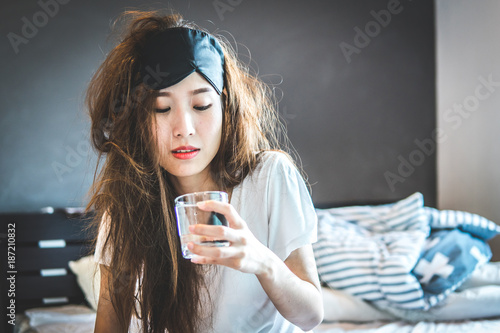 Fotomural Women drinking water by the bed after a night of drinking alcohol