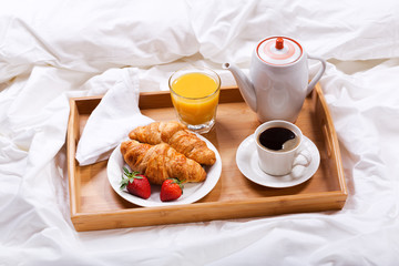 Wall Mural - breakfast tray with coffee and croissants in bed