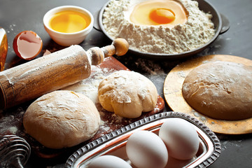 Wall Mural - Dough with flour on an old background in a composition with kitchen accessories