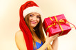 © Voyagerix - Woman in santa claus hat holds gift box. Christmas time