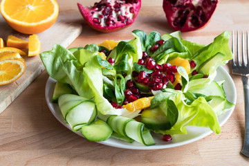 Wall Mural - Vegetable salad with orange slices and pomegranate seeds
