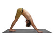 People, health, strength, flexibility and determination. Studio shot of athletic unshaven young European male doing Adho Mukha Svanasana or downward facing dog asana on mat, during group yoga class