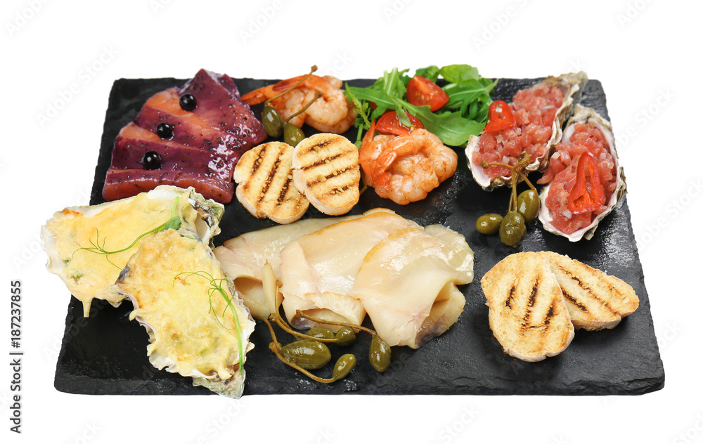 Slate plate with various seafood snacks on white background