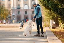 Handsome Young Hipster With Dog Outdoors