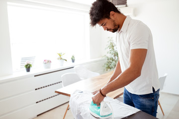 Wall Mural - Man ironing shirt on ironing board