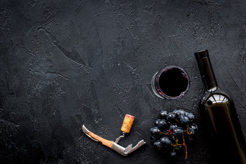 Open the wine. Corkscrew near bottle on black background top view copyspace