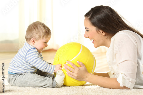Fototapeta Mother playing with her baby on the floor