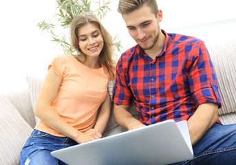 Wall Mural - Happy modern couple surfing the net and working on laptop at home