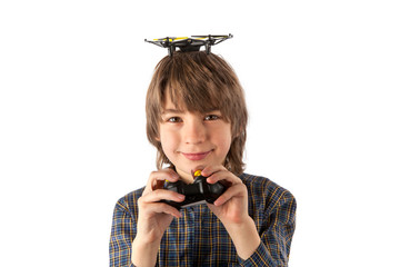 Smiling boy with a drone on top of his head and holding the quadcopter's remote control. Isolated on white background.