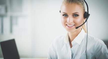 Portrait of beautiful businesswoman working at her desk with headset and laptop