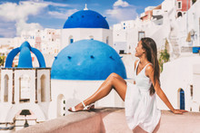 Travel Luxury Europe Vacation Woman At Blue Dome Church Famous Tourist Attraction European Destination In Oia, Santorini, Greek Islands, Greece.