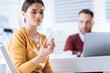 © zinkevych - Useful drops. Smart attentive ill woman looking at the nasal drops in her hand before using them while her busy colleague sitting in front of a laptop