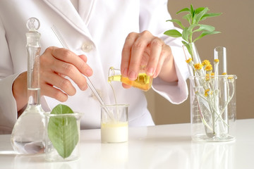 the scientist,dermatologist testing the organic natural product in the laboratory.research and development beauty skincare concept.blank package,bottle,container .cream,serum.