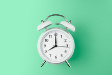 Vintage Alarm Clock On The Middle Of Solid Light Green Color Background