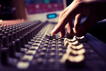 male sound engineer hands working on sound mixer for recording, broadcasting, music production background