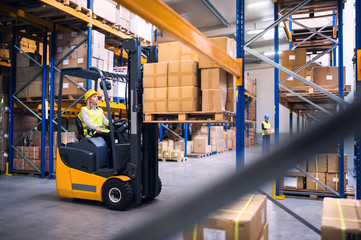 Poster - Young warehouse workers working together.